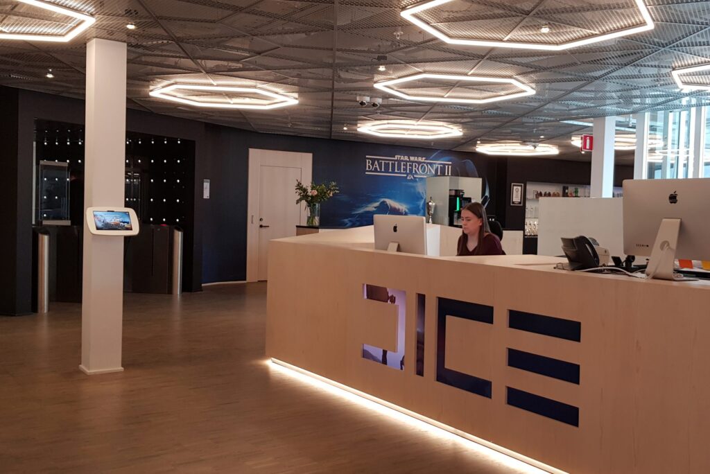 DICE-reception med trädisk, sexkantiga LED-armaturer i taket och Battlefront-vägg bakom.